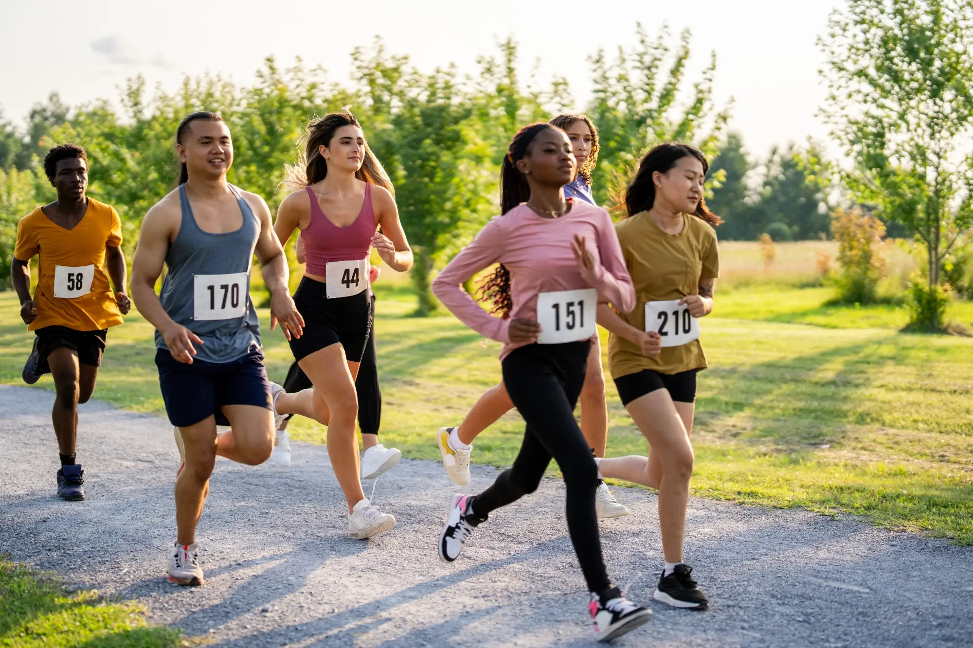 Four diverse women running outdoors in a race.